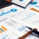 Pénzügyi jelentés grafikonokkal és táblázatokkal az asztalon.