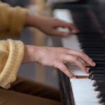 Egy kéz játszik a zongorán, a zene gyógyító erejét szimbolizálva.