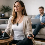 Nő meditál shungit kövekkel, háttérben férfi laptopozik.