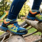 Gyerek a Skechers cipőjében fán mászik a játszótéren.